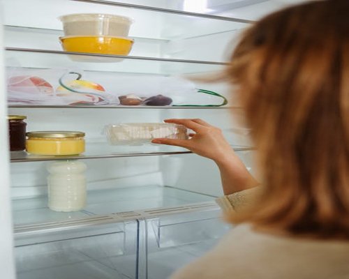 A neat refrigerator inside showcasing well-organized food containers and glass jars